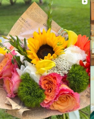 Bespoke orange and yellow floral arrangement with textural greenery